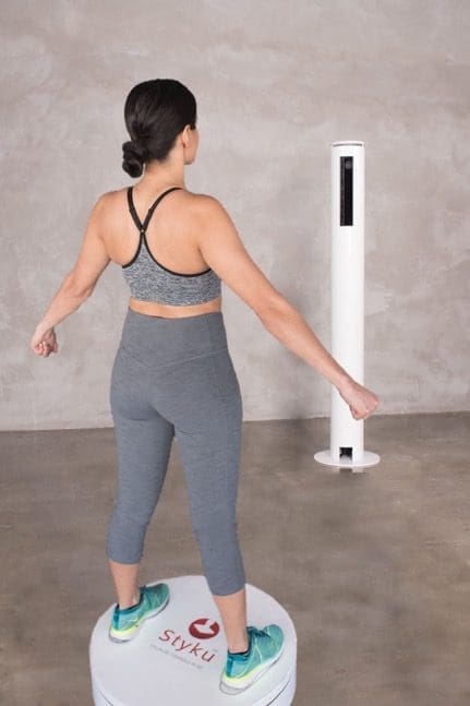Woman using Styku body scanner.