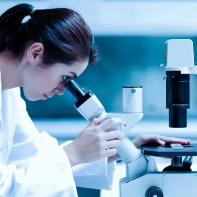Scientist using a microscope in a lab.