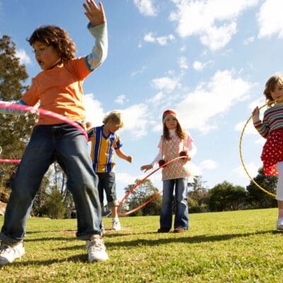 Kids playing with hoops outdoors.